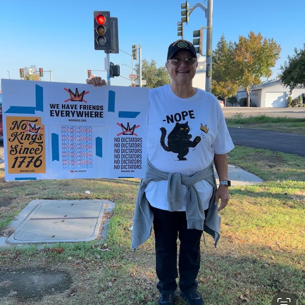 Mirror selfie in No Kings tee under a flannel jacket