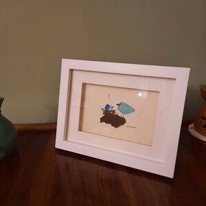 小石アートとシーグラスの絵画 - 額装された手作りの巣を作る鳥たち
