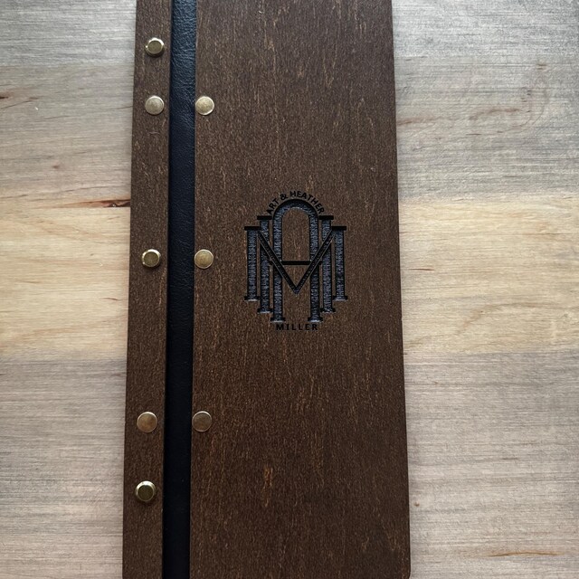 革ストラップに固定されたワインリスト用の木製メニューフォルダー