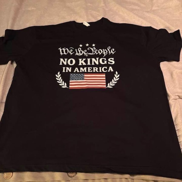 Group shot holding signs, all in matching anti-crown shirts