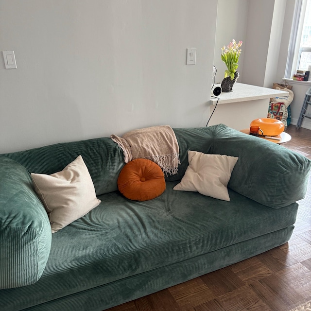 Deep green corduroy sofa with cream cushions in a white room, photographed by the buyer