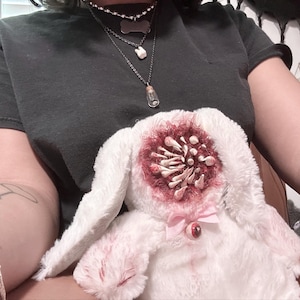 gory two headed teddy bear, blood teeth, bloody tooth, gore cute, horror creepy, pink ribbon, red white, menhera yandere, stuffed animal