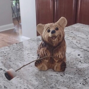 チェーンソーで彫られたマシュマロ付きのクマ。ウェルカムベア