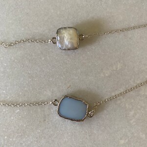 Repossi. Bague chevalière en or gris, ornée au centre d'un cabochon de