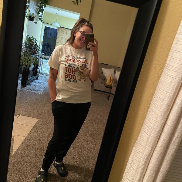 Customer wearing printed graphic tee, laughing