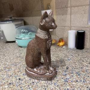 エジプトの女神バステトの猫の像、前面にスカラベ、ホルスの目、花崗岩