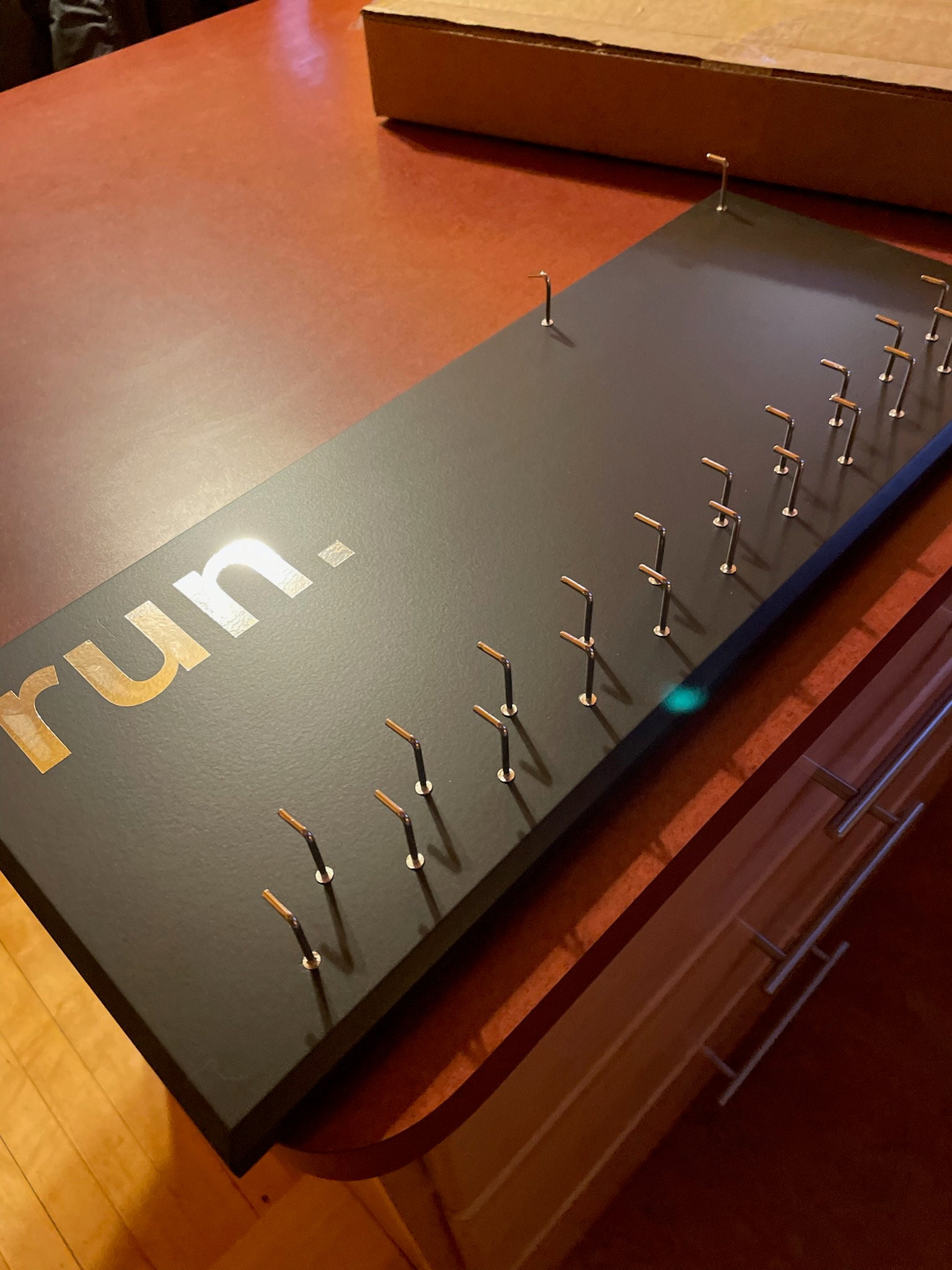 Running Medal Holder, gray or black with chrome "run." vinyl, 21 hooks and BIB holder