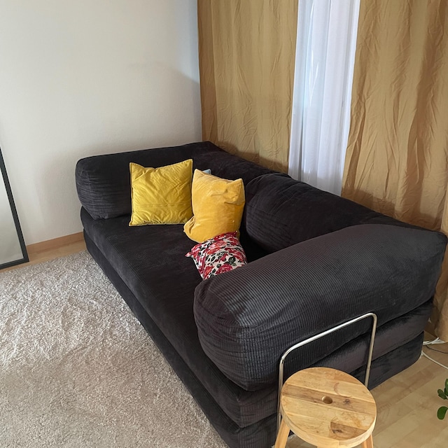 Charcoal sofa with mustard and patterned cushions against a wood-panelled wall, photographed by the buyer