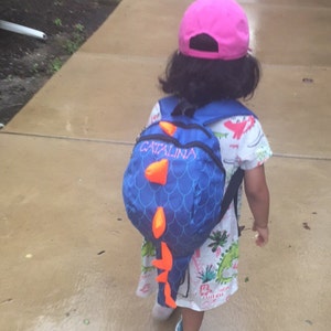 dinosaur wearing a backpack