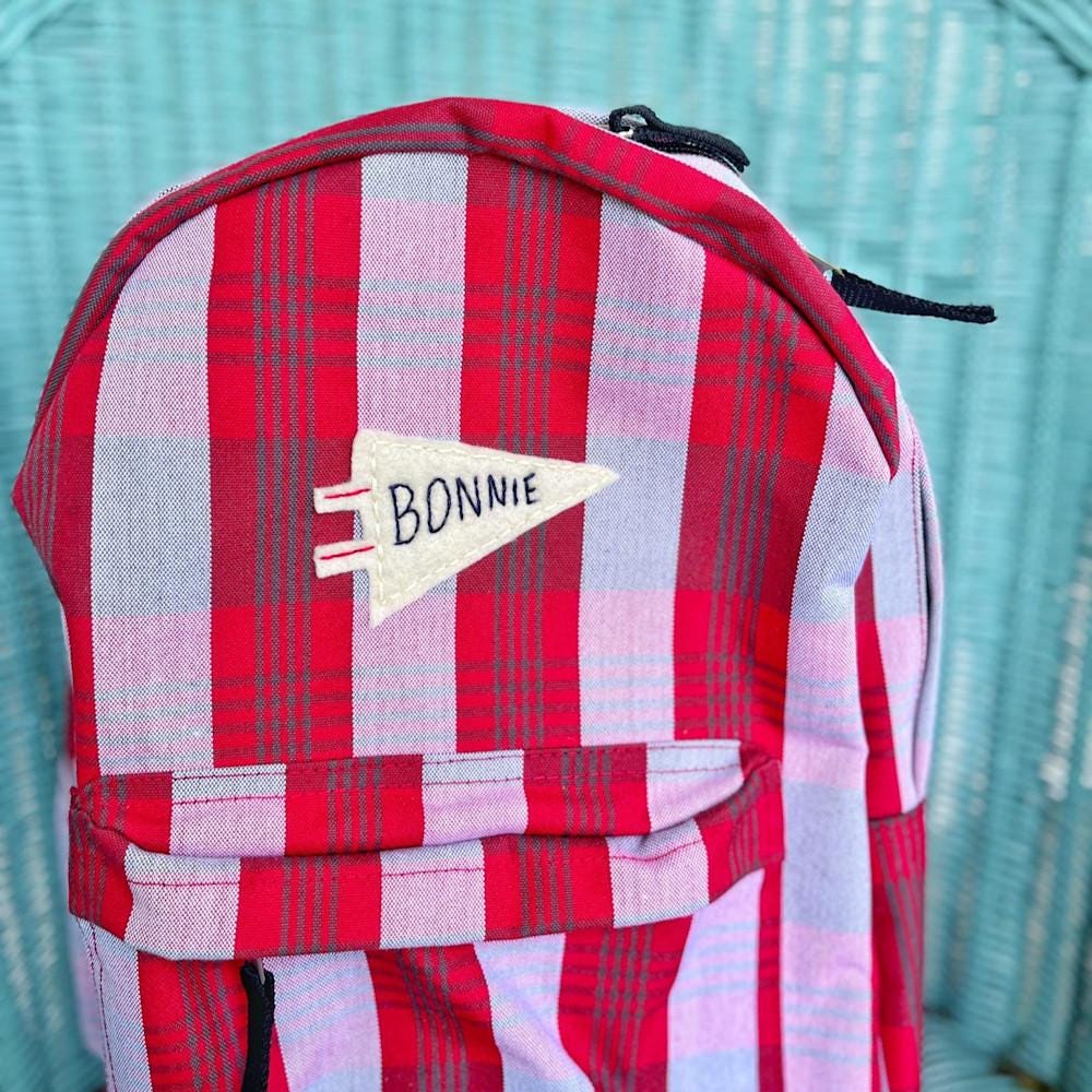 Plaid backpack with embroidered name pennant flag on it