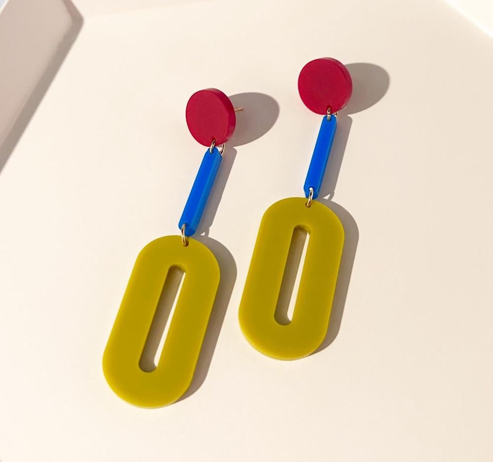 A pair of color blocked dangle earrings in the colors mustard, cobalt and cherry red.