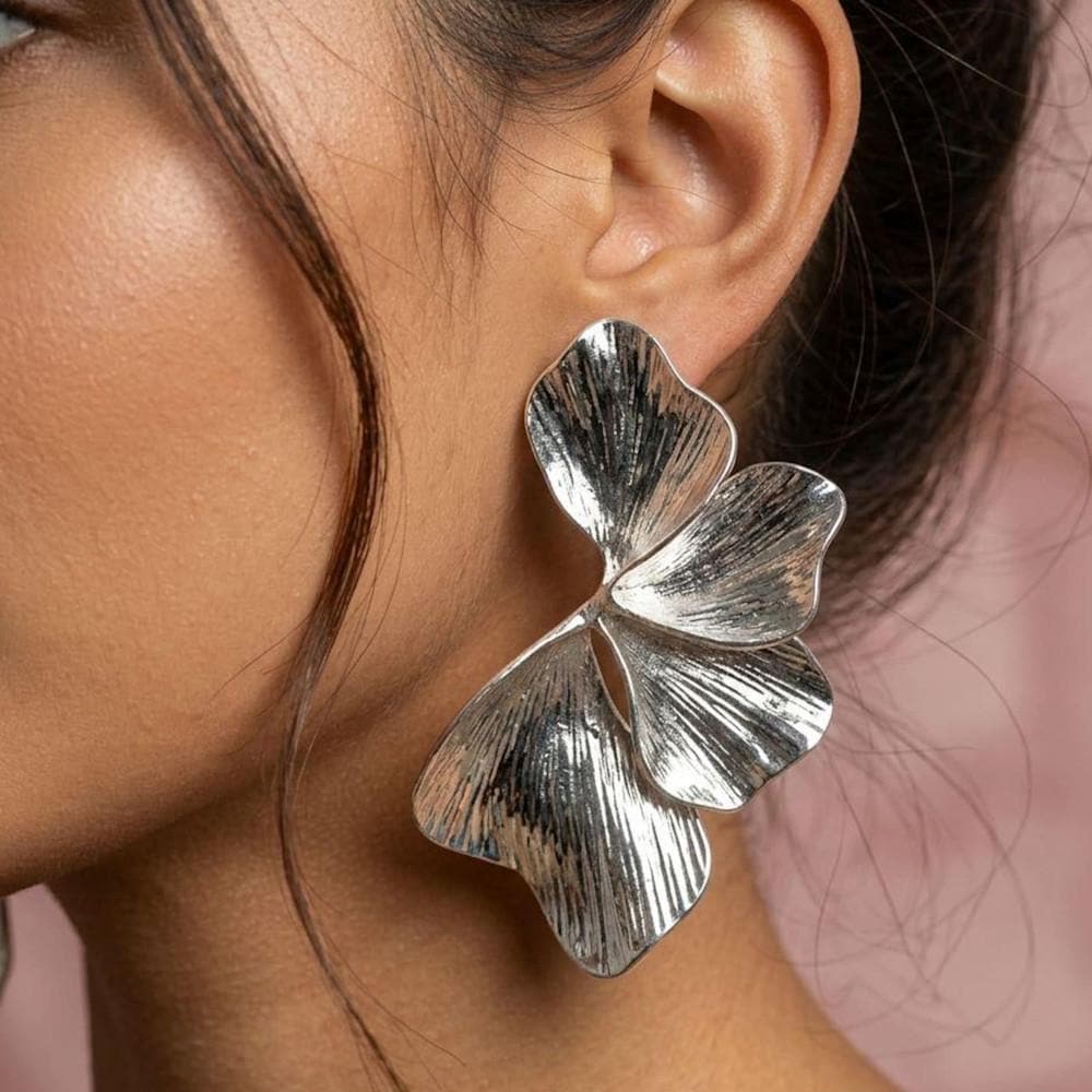 Brincos marcantes prateados com motivo floral