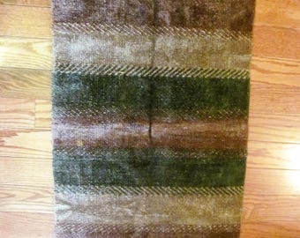 Rag rug.Woven greens and browns stripes pattern.Oblong