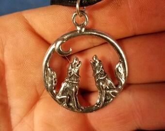 This is a pewter 2 wolves howling at the moon pendant necklace
