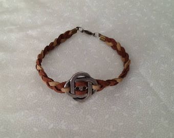 Faux Suede braided bracelet with a center metal charm.