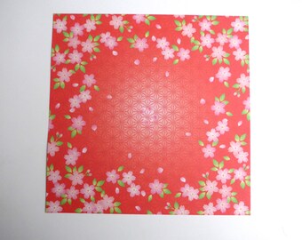 Sheet of origami paper (washi) double-sided patterned cherry blossoms on red background (front).