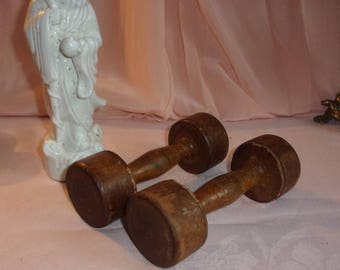 a pair of small old wooden dumbbells