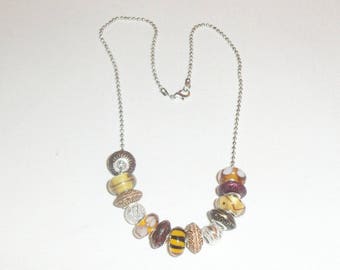 Necklace made of a thin chain balls ovals charms gemstones