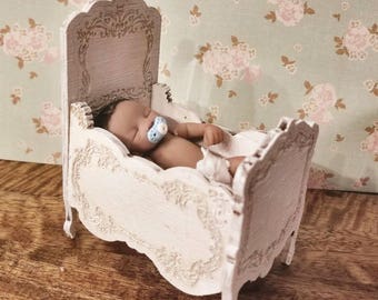 Miniature dollhouse crib with delicate detailing and finished in an antique chalky french white 1:12 scale