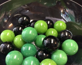 Solid color glass marbles, green and black. 23 count.