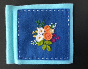 blue and aqua needle book with appliquéd and hand embroidered flowers and leaves
