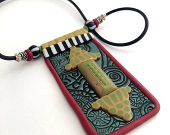 Pendant with applied design in middle eastern or African flavor, made by Marie Segal 2006