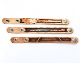Burned and painted leather wristbands with snaps
