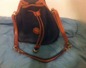 Dooney & Bourke drawstring bucket bag in navy all weather leather with British tan trim