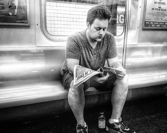 Man reading a newspaper on the subway