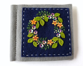 gray and blue hand embroidered needle book with sequins