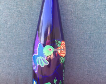 Painted recycled wine bottle with hummingbirds and lights inside