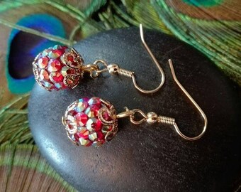 Golden color reflection/red rhinestone earrings.