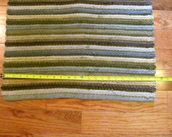 Rag rug.Woven greens and browns stripes pattern.Oblong