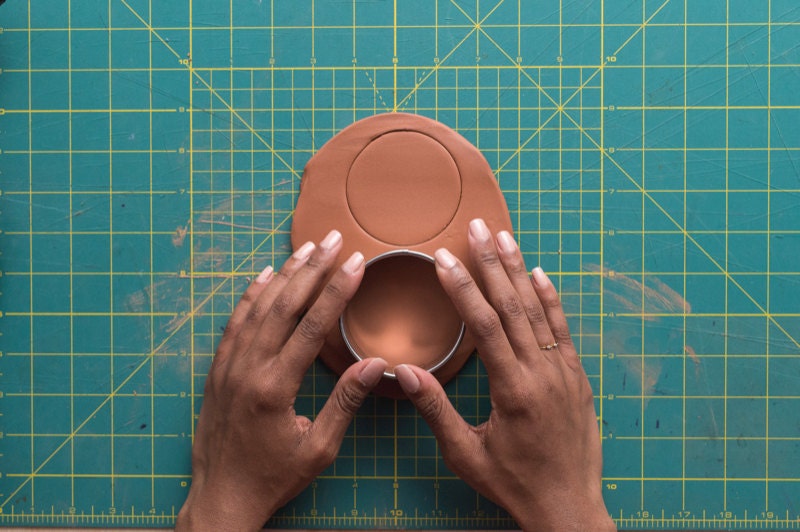 Image of hands with cookie cutter in clay. Image of hands with cookie cutter in clay.