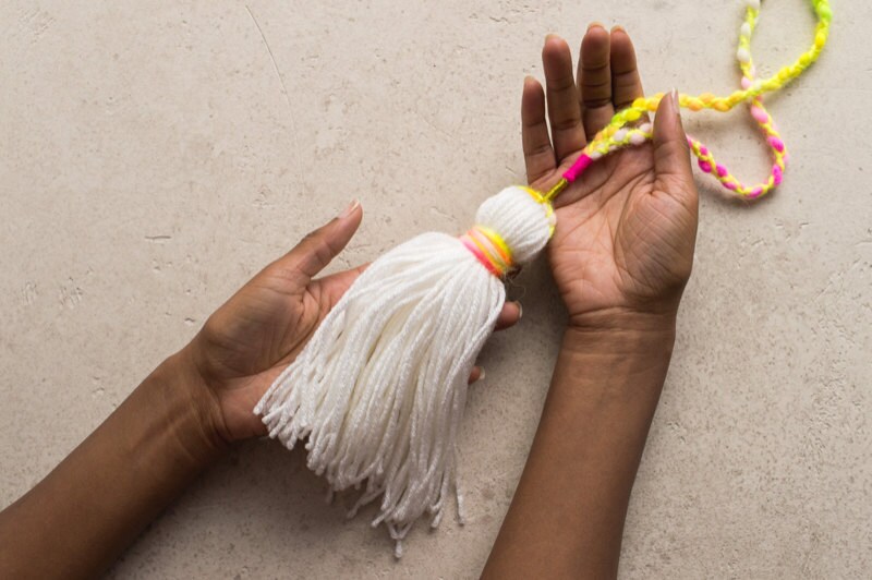 Hands hold a finished tassel. Hands hold a finished tassel.