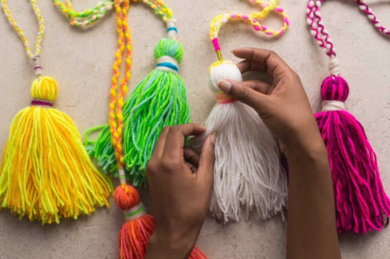 Hands holding multiple completed, colorful tassels. Hands holding multiple completed, colorful tassels.