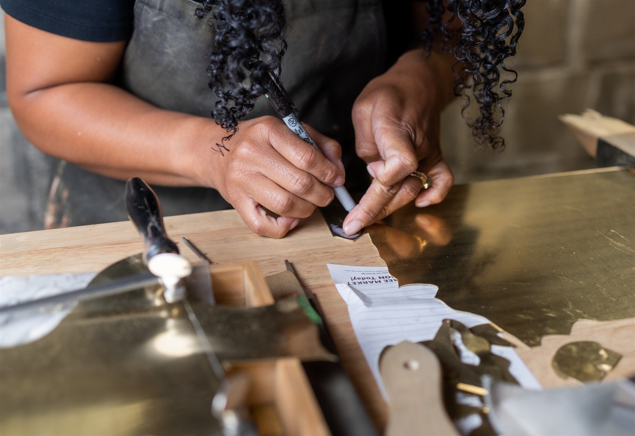 Close-up of Jordan Clarke's hands making jewelry in her studio.