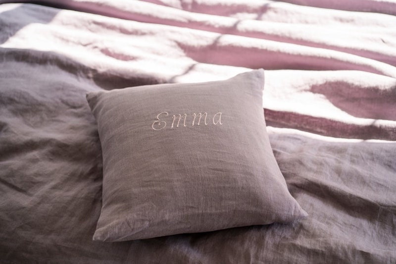 A personalized linen throw pillow with someone's name.