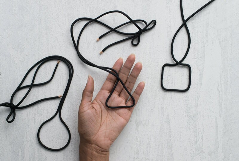 Image of hand with three finished necklaces in different shapes. Image of hand with three finished necklaces in different shapes.