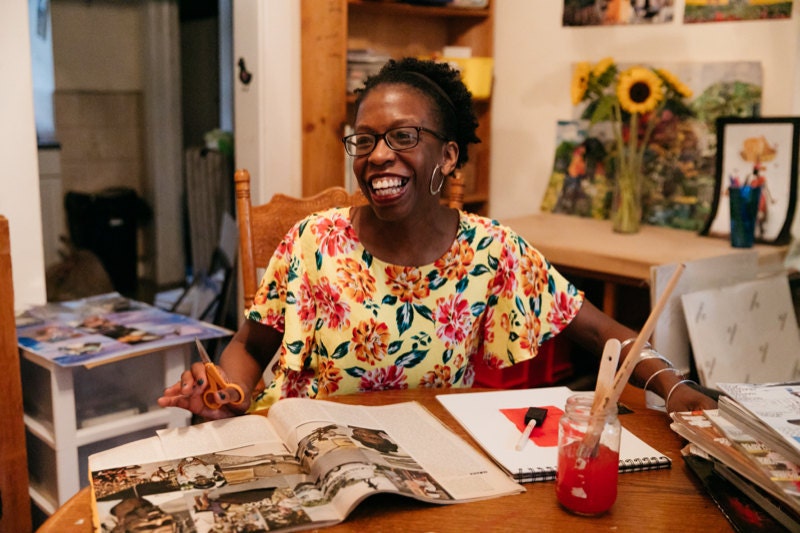 Mirlande at her dining room studio table, working on a collage.