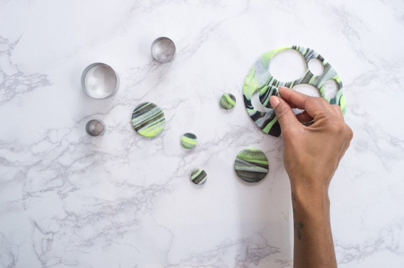 Hands cutting out shapes with a circle cookie cutter. Hands cutting out shapes with a circle cookie cutter.
