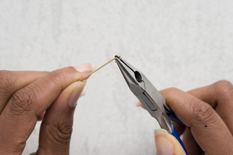 Image of hands bending the wire ends using flat-nosed pliers. Image of hands bending the wire ends using flat-nosed pliers.