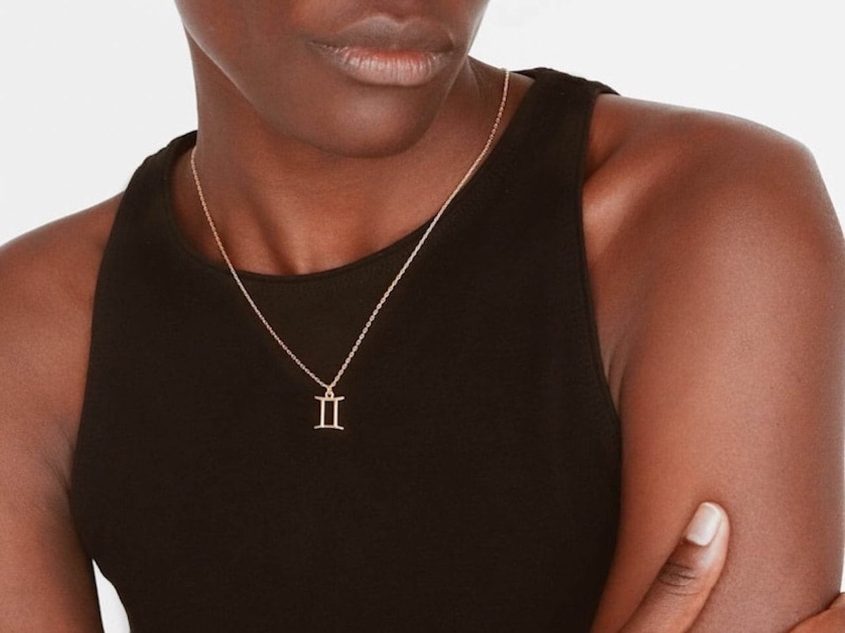 Unique personalized gifts: a Black woman wearing a gold Roman numerals necklace.