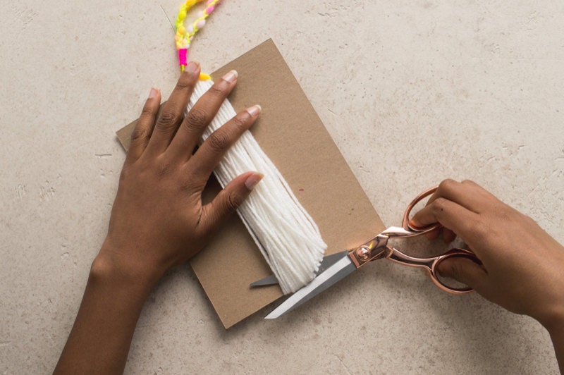 Cutting the tassel body loose from chipboard. Cutting the tassel body loose from chipboard.