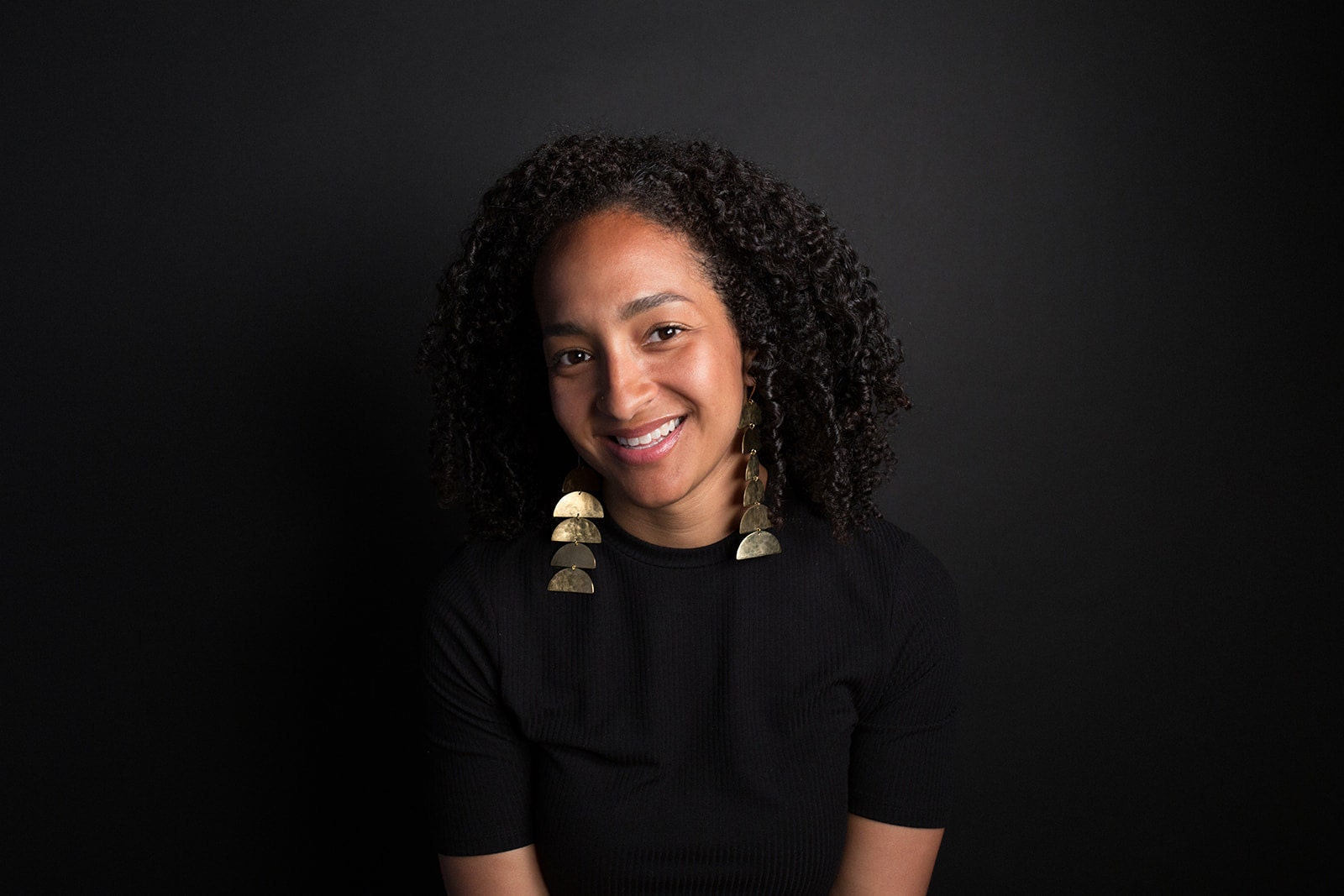 Jordan Clarke smiling while wearing a pair of her Enarmoured earrings.