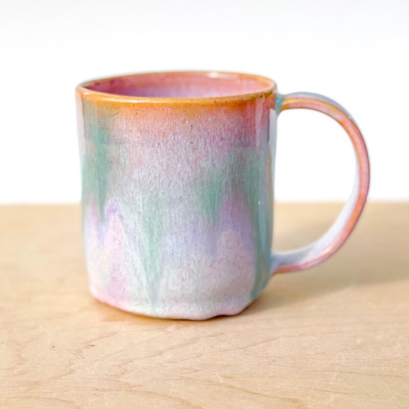 A pottery mug featuring blended pastel colors.