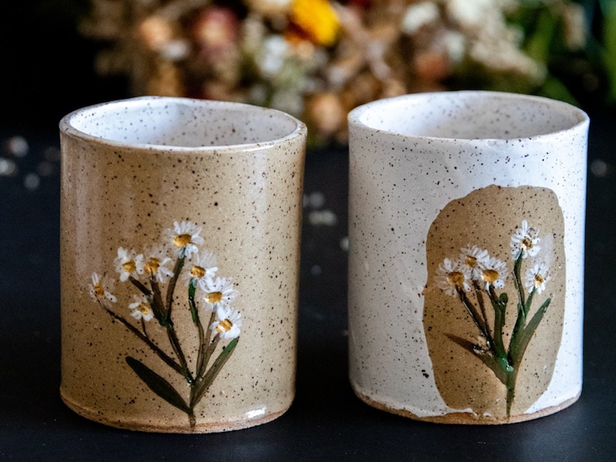 Best Coffee Mugs: two daisy-pressed ceramic coffee mugs.