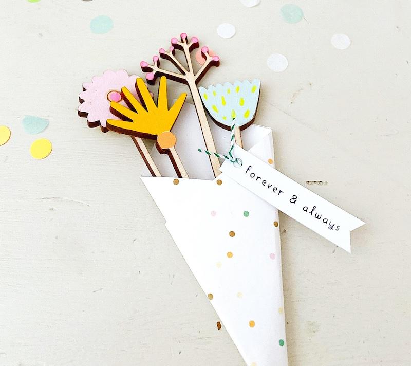 Laser-cut wooden bouquet wrapped in polka-dotted paper.