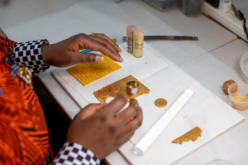 Dorianne from Atiwo Designs making jewelry in her studio.