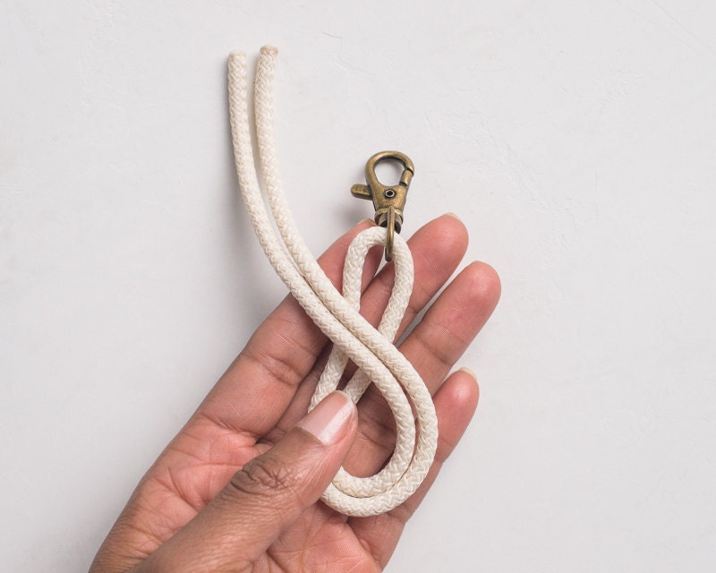 Hand holding rope ends so the bottom of the '8' is formed.
